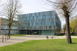 Modern glass and metal building with geometric lines, known as the Hub at the Université de Picardie Jules Verne in Amiens, France